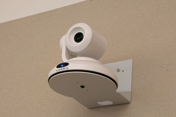 Camera mounted to a wall and instructor enabled adjustments to the lens to allow the instructor to be "seen" by the camera in more locations around the room