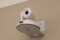 Camera mounted to a wall and instructor enabled adjustments to the lens to allow the instructor to be "seen" by the camera in more locations around the room