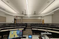 Back of room view of student tiered fixed-table and chair seating 