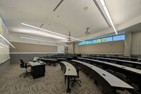 Back of room view of student tiered fixed-table and chair seating 