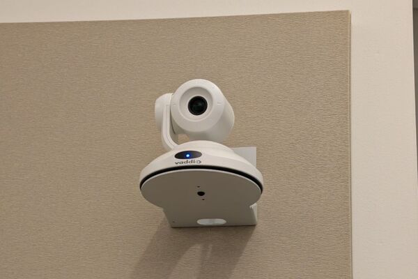 Camera mounted to a wall and instructor enabled adjustments to the lens to allow the instructor to be "seen" by the camera in more locations around the room