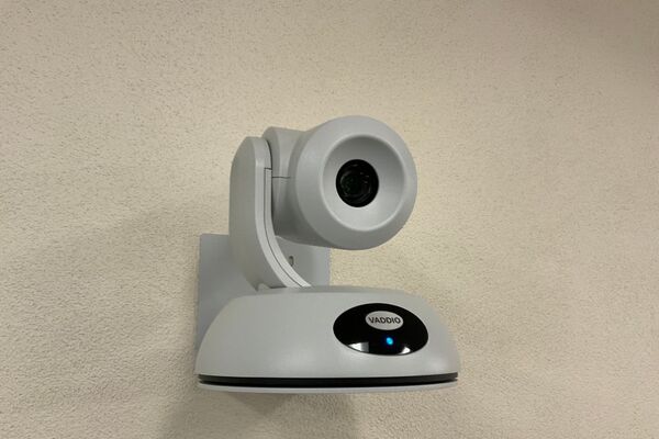 Camera mounted to a wall and instructor enabled adjustments to the lens to allow the instructor to be "seen" by the camera in more locations around the room