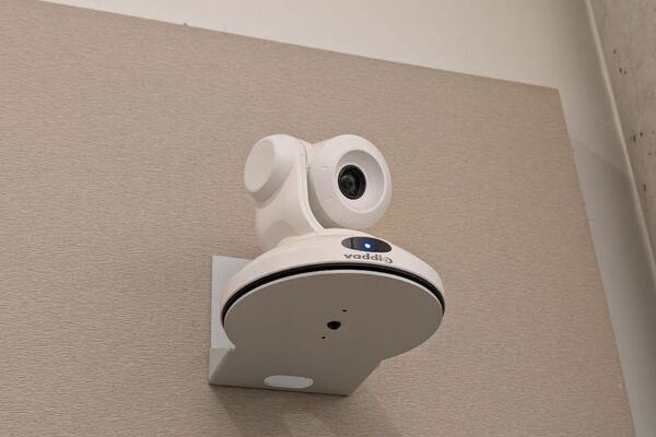 Camera mounted to a wall and instructor enabled adjustments to the lens to allow the instructor to be "seen" by the camera in more locations around the room
