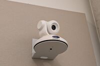 Camera mounted to a wall and instructor enabled adjustments to the lens to allow the instructor to be "seen" by the camera in more locations around the room