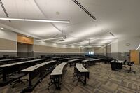 Back of room view of student tiered fixed-table and chair seating 
