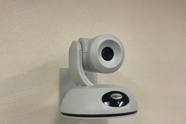 Camera mounted to a wall and instructor enabled adjustments to the lens to allow the instructor to be "seen" by the camera in more locations around the room