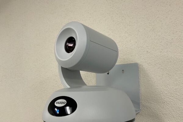 Camera mounted to a wall and instructor enabled adjustments to the lens to allow the instructor to be "seen" by the camera in more locations around the room