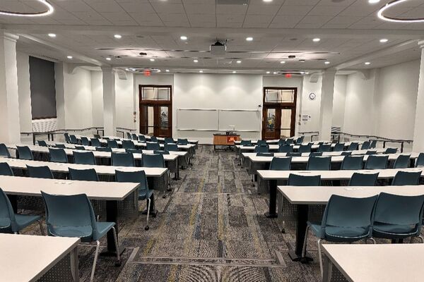 Front of room view with lectern in front of markerboard and exit doors to left and right