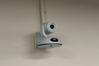 Camera mounted to a wall and instructor enabled adjustments to the lens to allow the instructor to be "seen" by the camera in more locations around the room