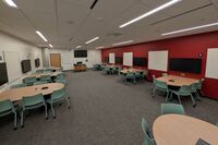 Front of room view with lectern center, two whiteboards on either side, and a projection screen above