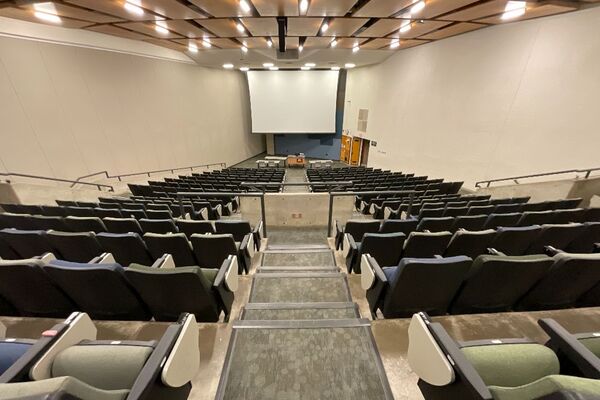 Front of room view with lectern center in front and projection screen lowered