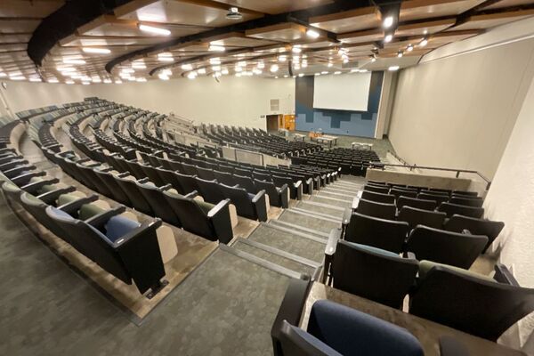 Front of room view with lectern in front and projection screen lowered