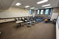 Back of room view of student tablet arm seating and markerboard on rear wall