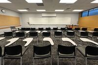 Front of room view with lectern on right in front of markerboard 
