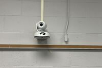 Camera mounted to a wall and instructor enabled adjustments to the lens to allow the instructor to be "seen" by the camera in more locations around the room