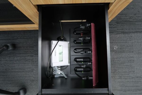 Pedestal - inside view of drawer showing assistive listening devices in charging base