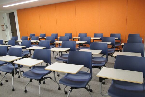 Rear of room view of student tablet arm chair seating on casters