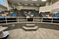 Back of room view of student auditorium seating, exit at back right corner