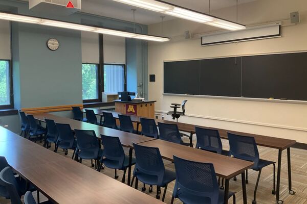 Front of room view with lectern on left side in front of chalkboard