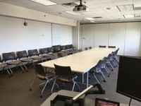 Photo of back of room from front of room, moveable tables and chairs.