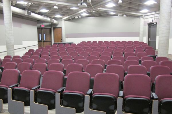 Back of room view of student auditorium seating and double exit doors on left