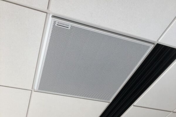 White 2 x 2 tile mounted in the ceiling to provide microphone coverage over student seating