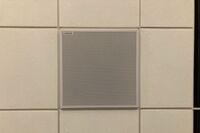 White 2 x 2 tile mounted in the ceiling to provide microphone coverage over student seating