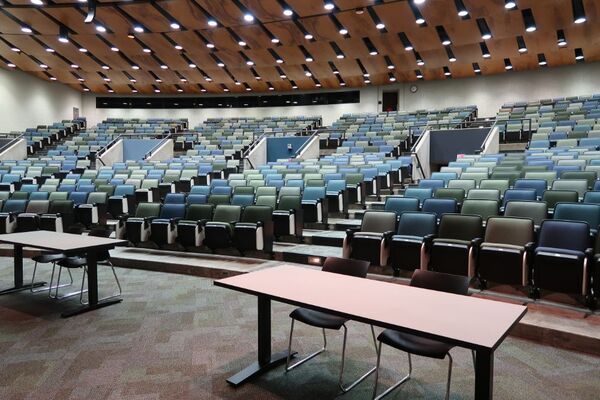 Back of room view of student auditorium seating and three exits at rear of room