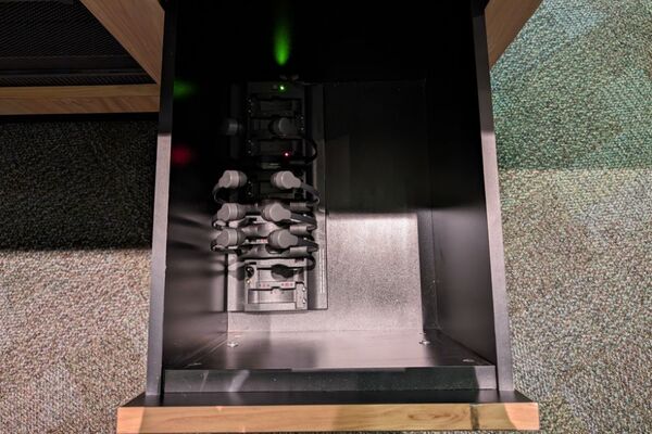 Pedestal - inside view of drawer showing assistive listening devices in charging base