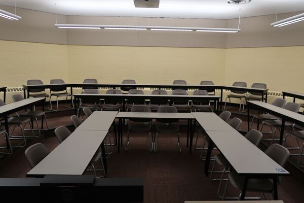Back of room view of student tiered fixed tables and chairs seating