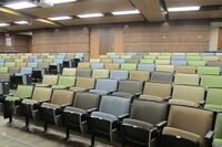 Back of room view of student auditorium seating and two exit doors at rear of room