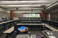 Back of room view of student tiered fixed table and chair seating 