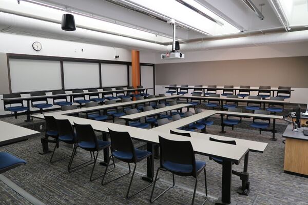 Back of room view of student tiered fixed-table and chair seating
