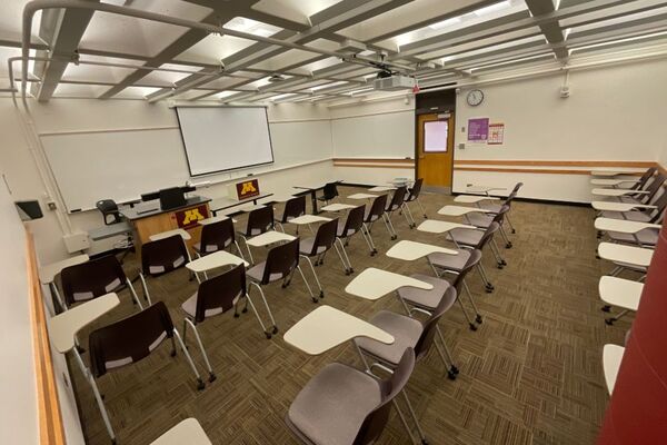 Front of room view with lectern on left in front of markerboard, exit on right