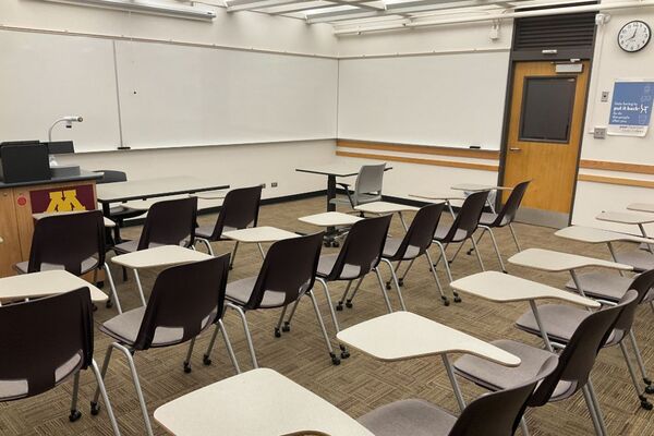 Front of room view with lectern on left and projection screen fully raised