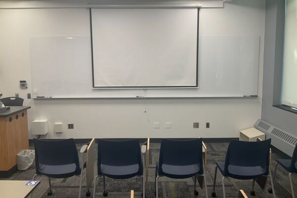 Front of room view with lectern on left in front of markerboard 