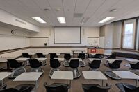 Front of room view with lectern on right in front of markerboard 