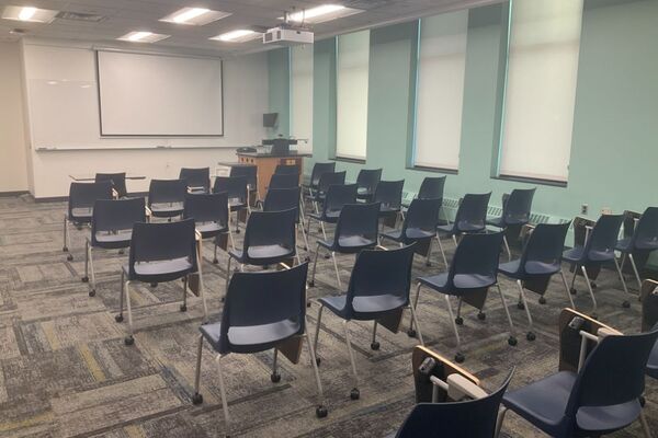 Front of room view with lectern on right in front of markerboard 