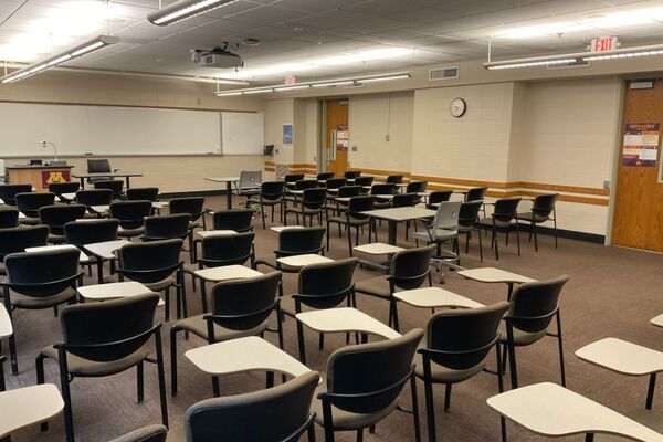 Front of room view with lectern on left in front of markerboard, and exit door on right wall