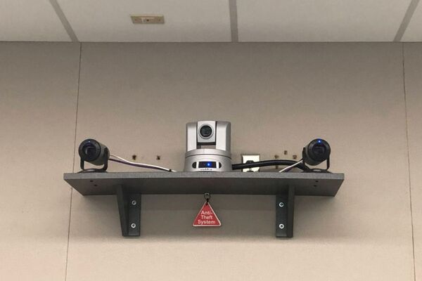 Camera mounted to a wall and instructor enabled adjustments to the lens to allow the instructor to be "seen" by the camera in more locations around the room