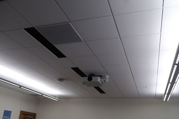 White 2x2 tile mounted in the ceiling to provide microphone coverage over student seating