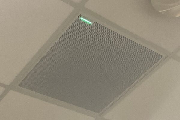 White 2 x 2 tile mounted in the ceiling to provide microphone coverage over student seating