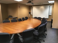Photo of front of room from back of room with a half moon conference table.