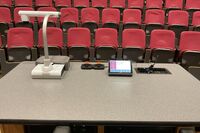 Pedestal - instructor view behind looking down at equipment rack, wireless microphones on charging base