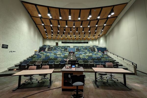 Back of room view of student auditorium seating and three exits at rear of room