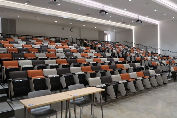 Back of room view of student auditorium seating and exit door at right side rear of room