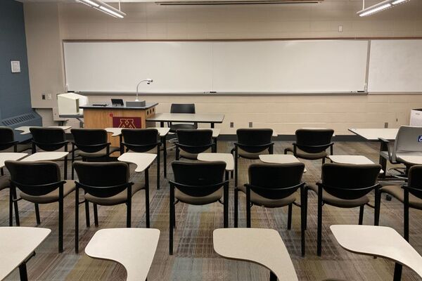 Front of room view with lectern center in front of markerboard, exit door on right wall