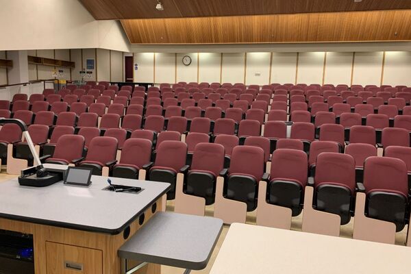 Back of room view of student auditorium seating and exit door at rear of room