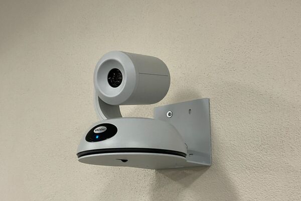Camera mounted to a wall and instructor enabled adjustments to the lens to allow the instructor to be "seen" by the camera in more locations around the room