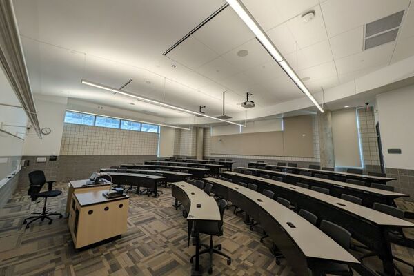 Back of room view of student tiered seating with fixed-tables and chairs